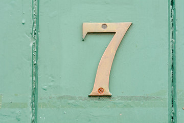 House number 7 sign on green painted door