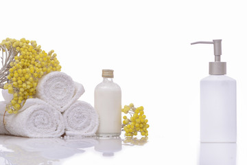 Fototapeta na wymiar Products for spa towel, spa oil, branch yellow flower
