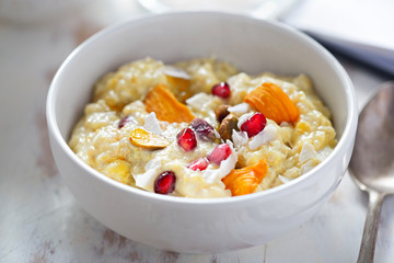Mango quinoa porridge with pomegranate, pistachios and dried fruits