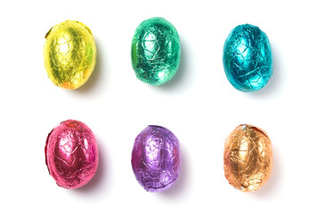 Chocolate easter eggs wrapped in multi colored foil isolated on white background