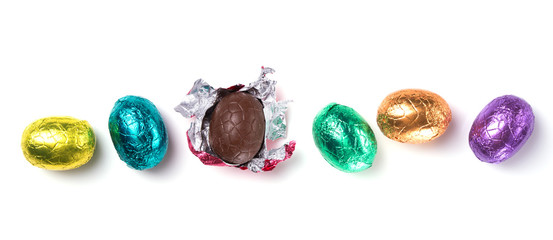 Chocolate easter eggs wrapped in multi colored foil isolated on white background
