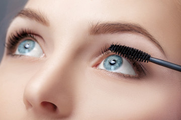 Naklejka premium Mascara brush close up. Make-up for blue eyes. Mascara applying