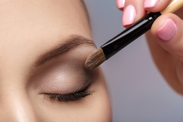 makeup artist apply makeup brush for eyes. makeup for young girl. brown eye shadow. close up - obrazy, fototapety, plakaty