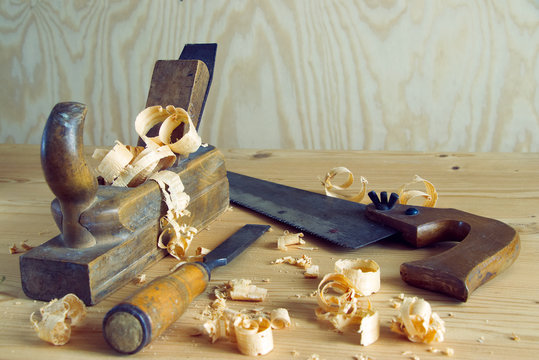 carpentry tools concept, vintage equipment for working with wood. planer, saw and chisel on wooden table with shavings 