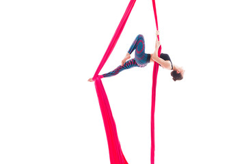 Woman hanging in aerial silks, isolated on white