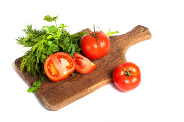 Red tomatoes with parsley on a wooden board