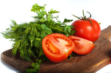 Red tomatoes with parsley on a wooden board