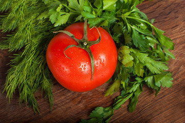 Red tomatoes with parsley on a wooden board