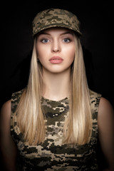 portrait of beautiful woman soldiers in military attire on black background