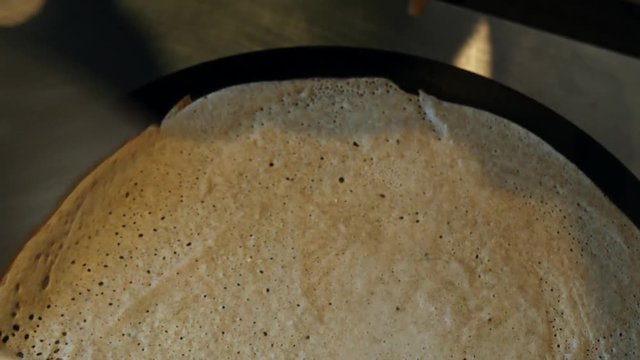 4K close up of a crepe cooking and heating, or buckwheat pancake, in Brittany. French traditional food specialty.  Galette bretonne, cr&ecirc;perie, Rennes, Bretagne, France.