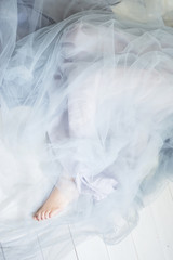 Barefoot woman with legs covered with transparent tulle