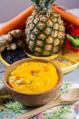 Bowl of spicy vegetable yellow curry sauce and all the ingredients that go into making it.  Used widely in Indian food.