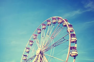Deurstickers Vintage stylized picture of a Ferris wheel against the blue sky. © MaciejBledowski