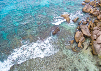 Seychelles Island La Digue aerial top view of a coastline with turquoise sea and granite rocks