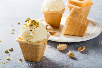 Waffle cups with homemade vanilla ice cream with pistachios nuts. Summer food concept.