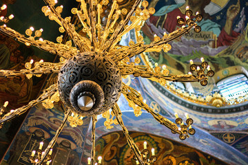 Vintage iron chandelier with floral twisted ornament gold color close-up in of St. Isaac's...