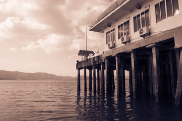 Ocean Waves with a house on the pier (sepia tone)