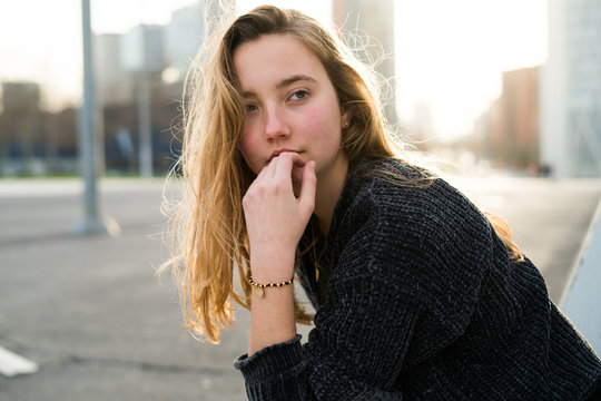 Thoughtful young woman sitting on the street