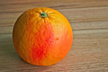 Closeup of a red grapefruit on a wooden table