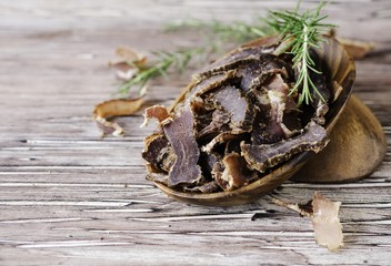 jerked meat, cow, deer, wild beast or biltong in wooden bowls on a rustic table