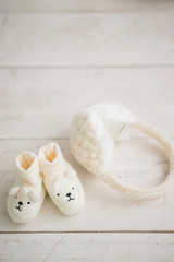 Close-up of baby's tiny boots and woolen earphones