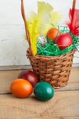 Easter eggs in basket and natural wooden country table copyspace