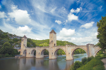 Fototapeta na wymiar Summer view of medieval stone Valentre Bridge with blu sky in Cahors, France
