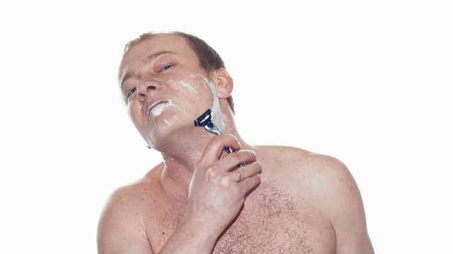 Adult man shaving with foam and manual razer. Slow motion