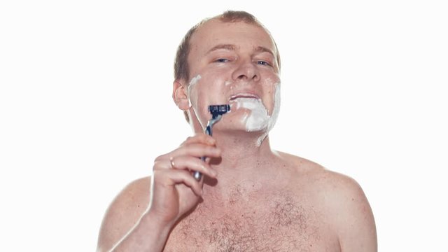 Adult man shaving with foam and manual razer. Slow motion
