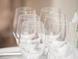 Row of empty wine glasses on bar counter.