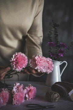 Graceful hands of the woman florist making bouquet of flowers