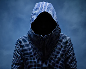 Invisible man in the hood.On blue background in smoke