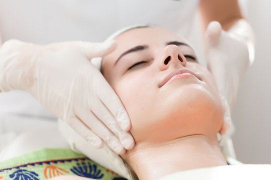 Facial massage.Beautiful young woman receiving facial massage at spa