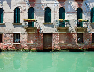 Fototapeta na wymiar Fassade of old venetian house standing in water. Venice, Italy.