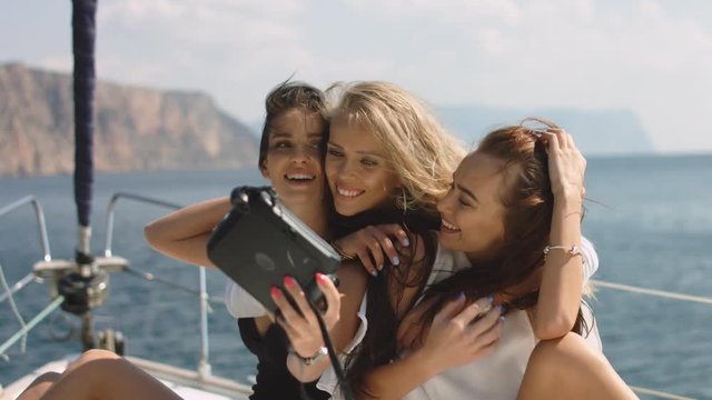 Beautiful girls taking a selfie on a white yacht