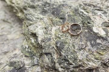 Two golden wedding rings on marble background in close-up