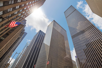 Photo of skyscrapers in Manhattan against the sun, looking up perspective, New York City, USA. 