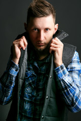 Fototapeta premium Man holds up his collar posing for the camera