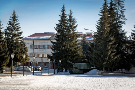 Monument on the square self-propelled howitzer among trees