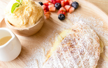 fresh dessert soft vanila roti with ice cream ,syrup ,strawberry and blueberry on plate in restaurant ,selective focus