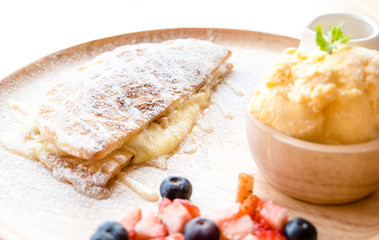 fresh dessert soft vanila roti with ice cream ,syrup ,strawberry and blueberry on plate in restaurant ,selective focus.