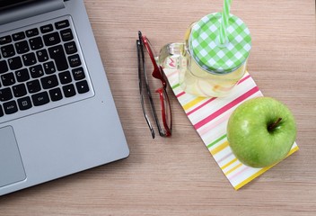 Desktop with green apple and lemonade 