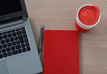 Laptop with red notebook and coffe