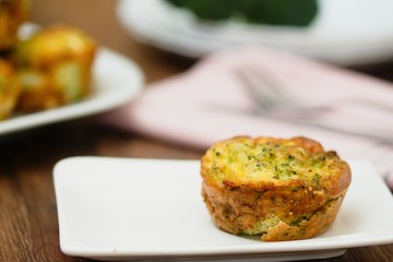 Broccoli savory cake served on white plate on a dark wood table