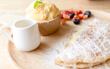 fresh dessert soft vanila roti with ice cream ,syrup ,strawberry and blueberry on plate in restaurant ,selective focus.