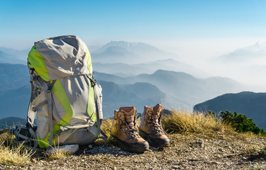 Hiking equipment. Backpack and boots on top of mountain.