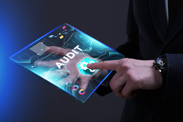 Business, Technology, Internet and network concept. Young businessman working on a virtual screen of the future and sees the inscription: Audit