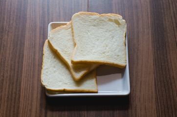bread on white plate on wood board.