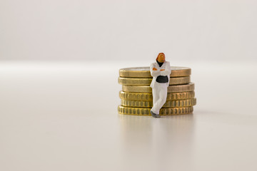 Mann lehnt sich an Geldstapel