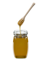 Honig fließt mit Honiglöffel in Honigglas